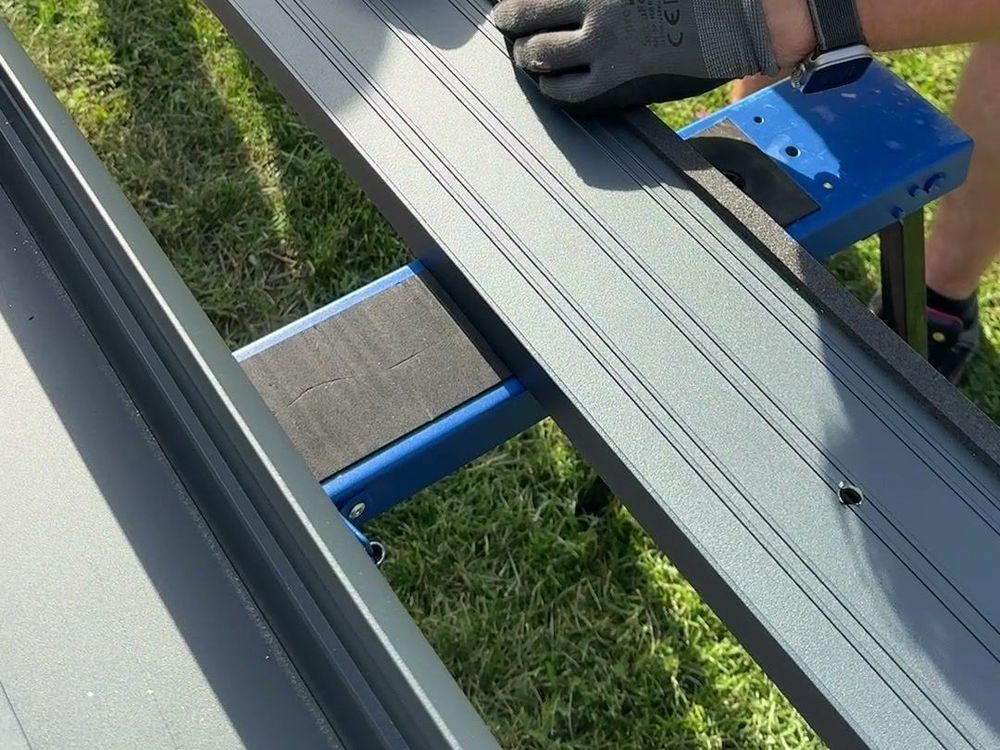 Dichtband wird auf den Aluminiumsparren einer Terrassenüberdachung aufgebracht