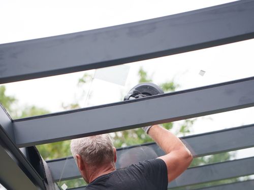 Einlegen einer VSG-Glasscheibe in die Sparren einer Terrassenüberdachung