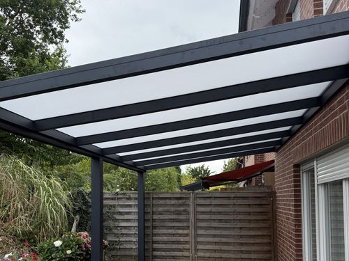 Terrassenüberdachung mit lichtdurchlässiger opaler Dacheindeckung an einem Reihenhaus